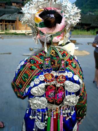 photo of China, Guizhou province, Miao girl of folklore group in traditional ethnic Miao costume, beautifully detailed back of her dress