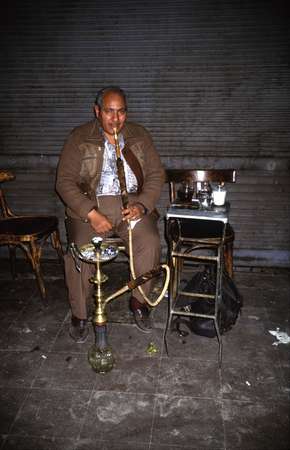 photo of Egypt, Egyptian man smoking water pipe (Shisha) on a street in Cairo