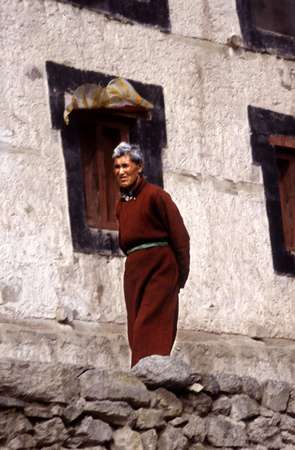 photo of India, Ladakh, around Leh, buddhist monk in front of the wall of a temple