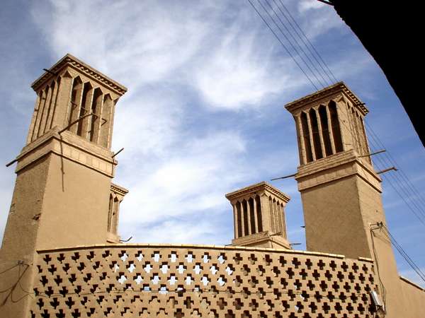 photo of Iran, Yazd, man on bicycle mud brick houses and the 'badghirs' or windtowers. Windtowers are a kind of medieval airconditioning, they funnel and speed up fresh air from the slightest breezes down to cool the interiors of the houses