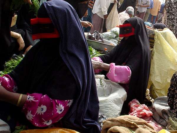 photo of Iran, Persian sea coast, around Bandar Abbas, women on the Thursday market in Minab wearing traditional borqas (burqa, burka), black and red masks which cover their whole face