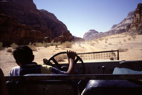 photo of Jordan, Wadi Rum desert, driving with a 4WD jeep through the red desert landscape full of granite and sandstone cliffs and rocks. The driver was 13 years old and was a bit to little to see the road in a normal way