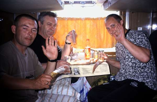 photo of Russia, along the trans siberian railway, eating and drinking in a Russian coupe. On Russian trains everyone shares his food and drinks with the other people in the coupe