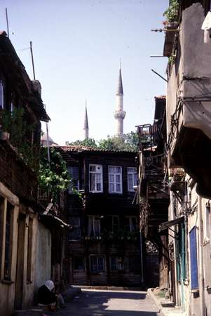 photo of Turkey, Istanbul, small street with wooden houses and minarets in the background