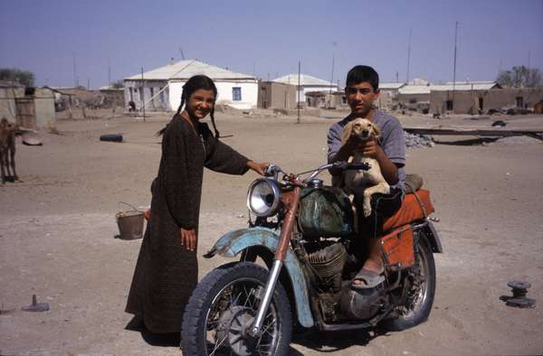 photo of Turkmenistan, Kara Kum desert, Yerbent (Jerbent) village, Turkmen children with colorful motorbike