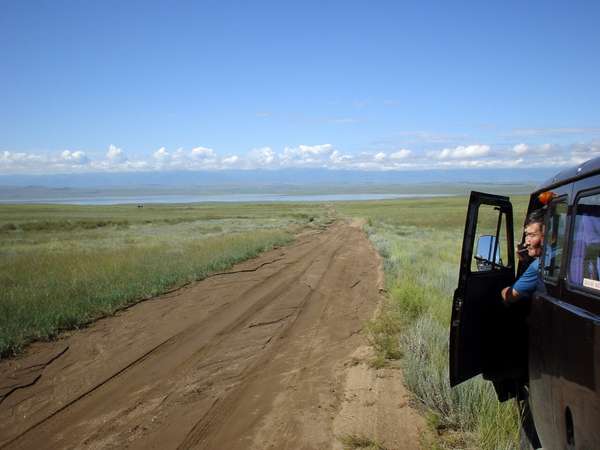 photo of Southern Tuva, with the UAZ bus jeep at the border of Mongolia, dirt track and lake Tore-Khol in the background