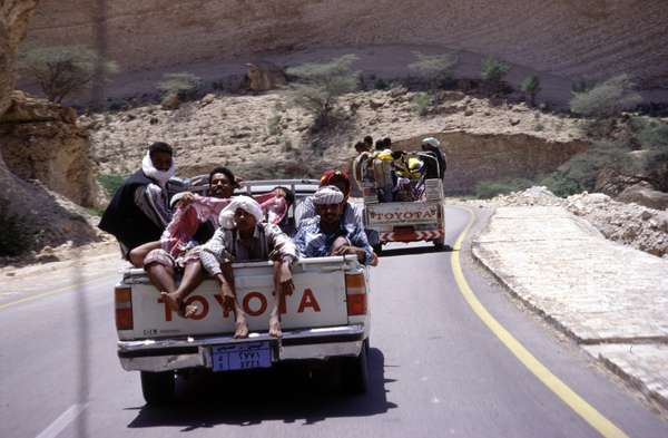 photo of South Yemen, Yemeni people in the trunk of Toyota Hilux 4WD jeeps on a good asphalted road to Al Mukalla