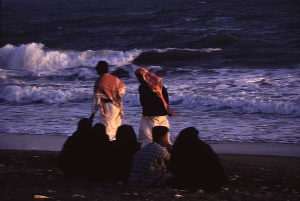 photo of Yemen, Gulf of Aden, Yemeni men and covered women on the beach of Al Mukalla