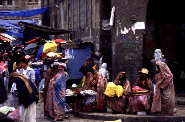 photo of Yemen, Sanaa souq market, Yemeni women in red selling bread