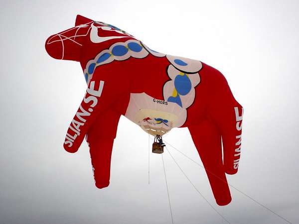 photo of Sweden, Mora, Dalarna Häst (horse) hot air balloon during Vasaloppet in Mora, the red and white little wooden horse is one of the most 'typical' (and useless) presents tourists take home from Sweden