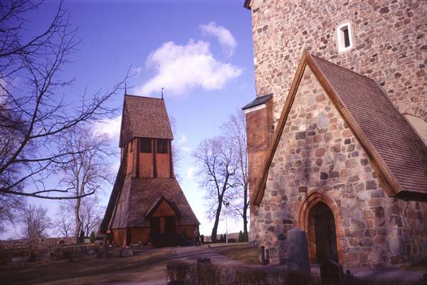 photo of Sweden, Old Uppsala, old red wooden church and graveyard in Gamla Uppsala