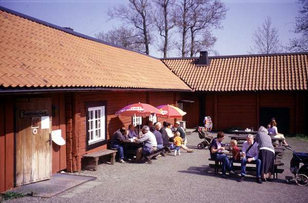 photo of Sweden, walkers taking a rest outside a restored Swedish farmhouse in Tyresta By, a tiny village at the start (and end) of the walks in the Tyresta National Park, the closest Swedish National Park to Stockholm