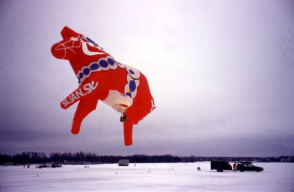 photo of Sweden, Mora, Dalarna Häst (horse) balloon attached to a Volvo on a frozen lake during Vasaloppet in Mora, the red and white little wooden horse is one of the most 'typical' (and useless) presents tourists take home from Sweden