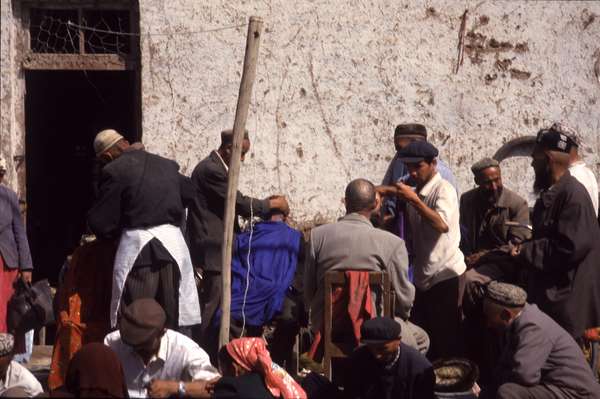 photo of China, Xinjiang province (East Turkistan), Kashi, Uygur are shaved bold by street hairdressers on the Kashgar Sunday market