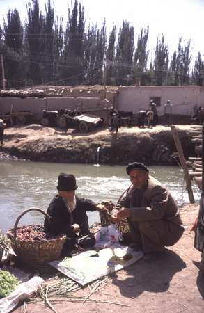 photo of China, Xinjiang province (East Turkistan), Kashi, Uygur farmers having their lunch on the Kashgar Sunday market