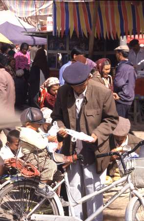 photo of China, Xinjiang province (East Turkistan), Kashi, old Uygur man with baby on bicycle on the Kashgar Sunday market