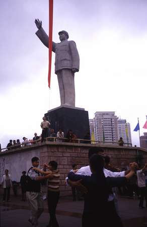 photo of Central China, Guiyang, Guizhou province, a lot of Chinese love to do early morning gymnastics before they go to work, here people are dancing walses below a statue of Mao at 6am in the centre of Guiyang