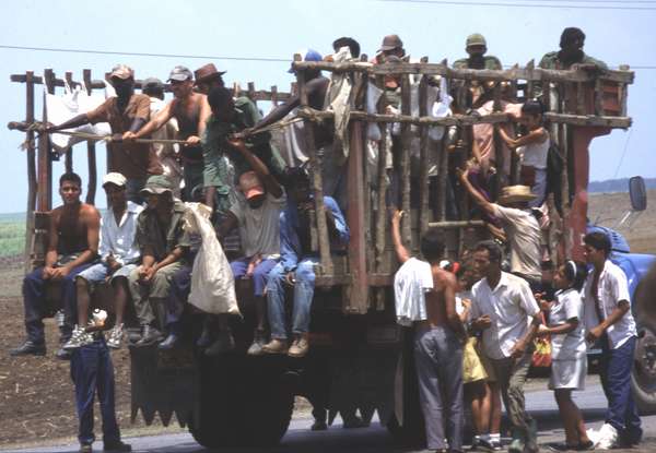 photo of Cuba, Cuban villagers mounting on an overloaded truck used for transport of people in the countryside