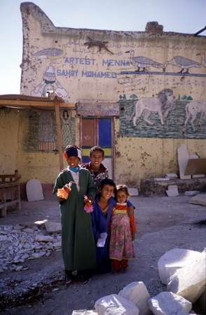 photo of Egypt, around Luxor, children with puppets in front of a house painted with lions and other animals