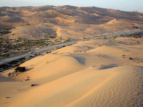 photo of United Arab Emirates, road with car through the sand dunes of Liwa oasis