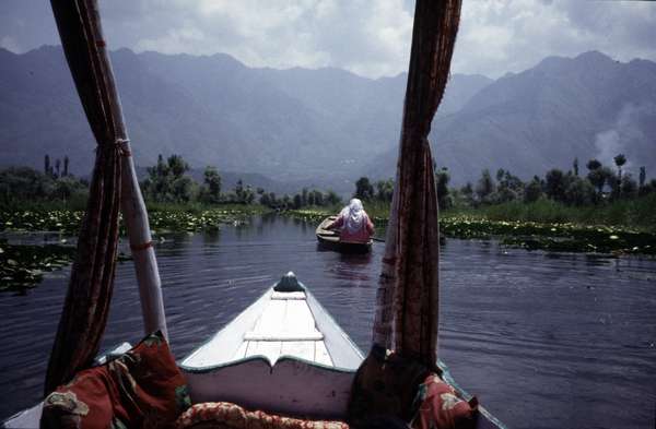 photo of India, Kashmir, Srinagar, girls in canoe as seen from a sringath (gondola-like boat with canopies) on Lake Dal