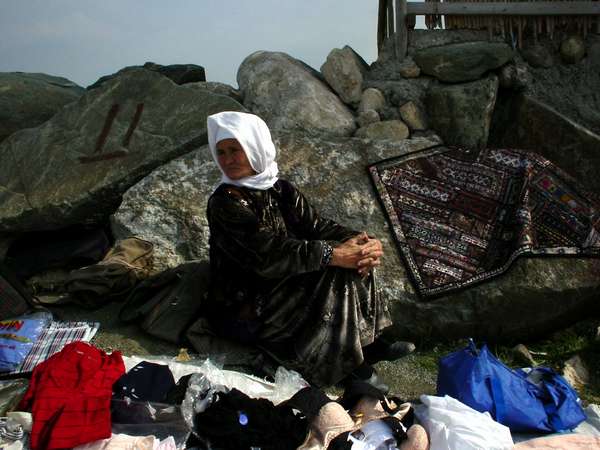 photo of Iran, Bandar e Turkoman, turkmen woman selling clothes on a marketplace next to the coastal rocks
