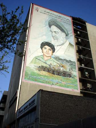 photo of Iran, Esfahan, propaganda billboard of the Iranian revolution and the Iran Irak war with Khomeini, a tank and a soldier martyr