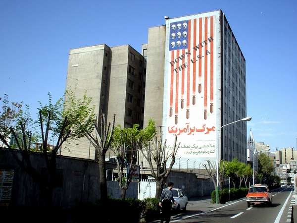 photo of Iran, Tehran (Teheran), propaganda billboard of the Iranian revolution on an appartment block, 'down with the USA', bombs falling from the American flag and skulls instead of stars