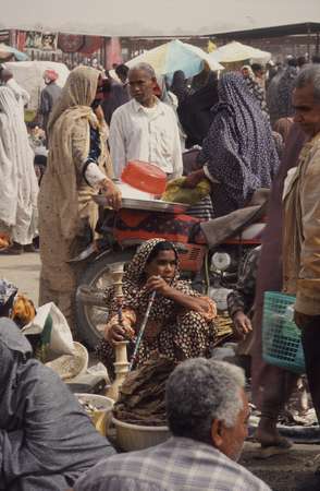 photo of Iran, Persian sea coast, around Bandar Abbas, market vendors and woman smoking water pipe on the Thursday market in Minab