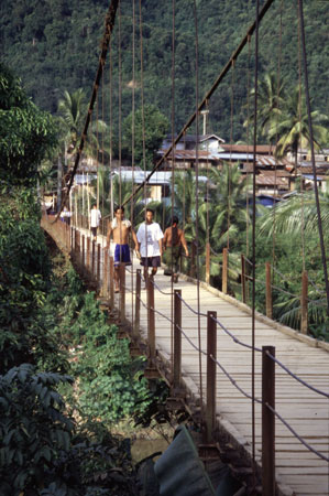 photo of Laos, Muang Khua village, Laotian people walking on a hang bridge over the Nam Ou River