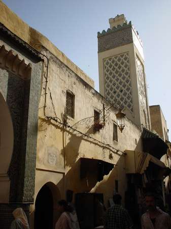 photo of Morocco, Fez (Fes) medina, street in the old souq (suq) with minaret of a mosque