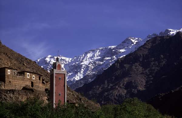 photo of Morocco, around Mount Toubkal, High Atlas mountains, berber house, mosque with minaret and snowy peaks