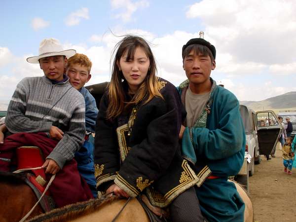 photo of Mongolia, in the fields outside Ulaan Baatar (Ulaanbaatar, Ulan Bator), cool Mongolian teenagers riding their horses on Nadam (Naadam), the Mongolian National holiday