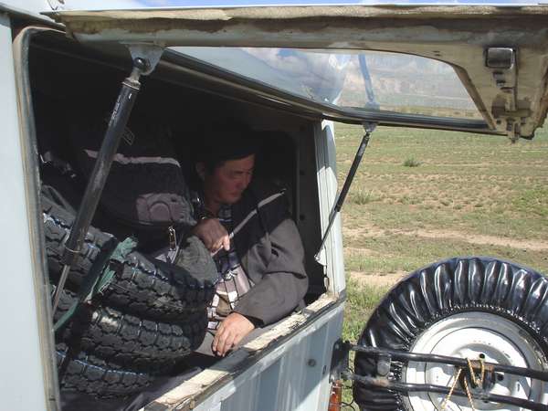 photo of Mongolia, Mongolian man in the trunk of a Russian UAZ jeep. There is no public transport outside the capital Ulaanbaatar. Taxi jeeps fill up the gap, but are extremely overloaded with people and luggage which makes every trip very uncomfortable