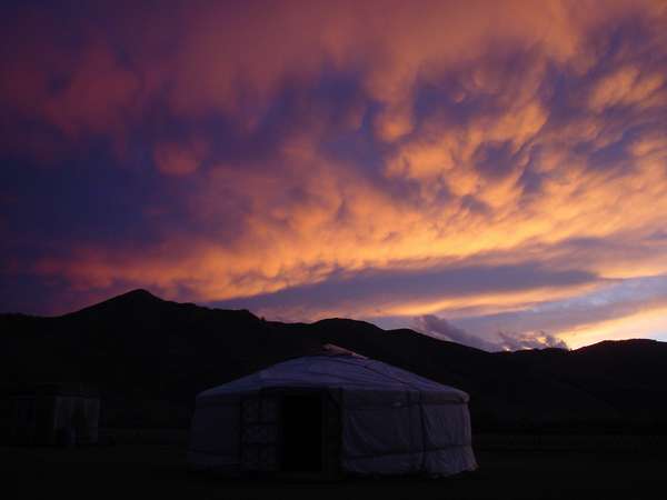 photo of Mongolia, red sunset clouds above a Mongolian nomadic tent (yurt)