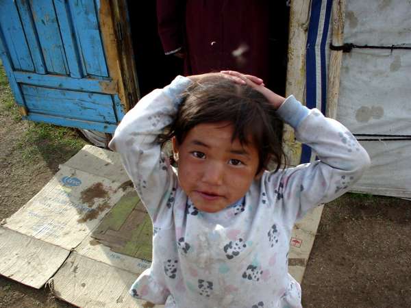 photo of Mongolia, Mongolian girl in front of a wooden house
