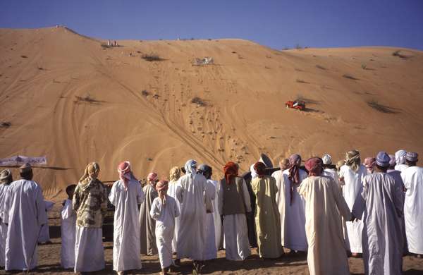 photo of Oman, Wahiba sands desert, wadi or dunes bashing car racing competition, 4WD jeeps drive up as high as possible on a steep orange sand dune