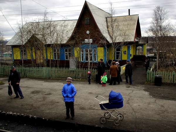 photo of Russia, girl with a baby buggy in front of a train station along the track from Sochi to Vorkuta