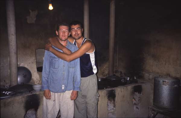 photo of Turkmenistan, around Darvaza, two Turkmen man in the kitchen of a truck stop - chaihana in the middle of the Kara Kum desert