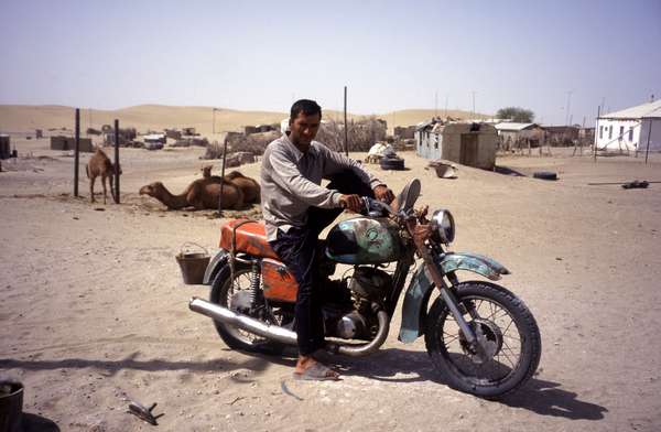photo of Turkmenistan, Yerbent (Jerbent), man on a colorful motorcycle in the Kara Kum desert town of Yerbent, along the road from Ashgabat to Konye Urgench