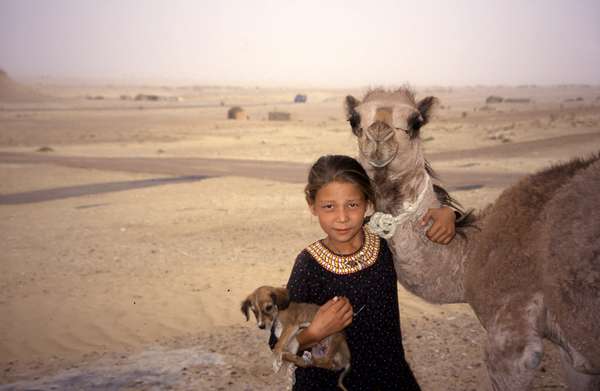 photo of Turkmenistan, meisje met hondje en de kameel in Darvaza, in het midden van de Kara Kum woestijn
