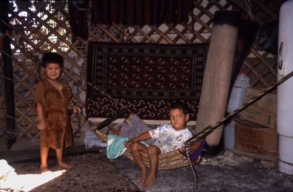 photo of Turkmenistan, Kara Kum desert, around Yerbent (Jerbent), Turkmen children inside a ger (yurt, nomads tent)