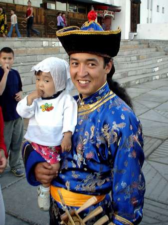 photo of Tuva, Kyzyl, outside the theatre, Dembildei Khoomei festival 2002, Tuvan throat singing musician in traditional dress with child