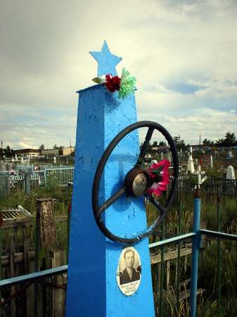 photo of Tuva, Kyzyl cemetery, blue Soviet communist grave with star and wheel of a bus or taxi driver