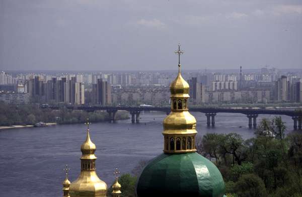 photo of Ukraine, Kiev (Kyiv), apartment blocks and bridge over the Dniepr (Dnipro, Dnieper) river seen from one of the green and gold church domes of the Caves Monastery (Pechersk Lavra)