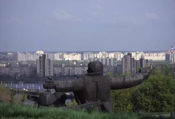 photo of Ukraine, Kiev, Shevchenko park, heroic scupture of hero of the great patriotic war with skyline of white and grey apartment blocks