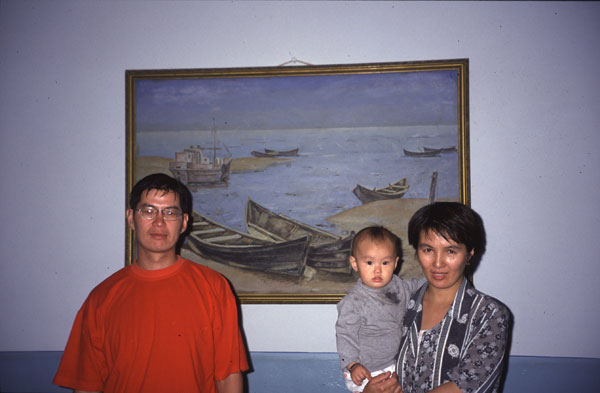 photo of Uzbekistan, around Moynaq (Moynak, Muynak), a former fishing village on the shores of the Aral Sea, owner of the Oybek hotel. Behind him is a painting of 1977 when the fisherman were still happily fishing in the Aral Sea, now the lake is so dried out that its shore has moved more than 100 kilometers away