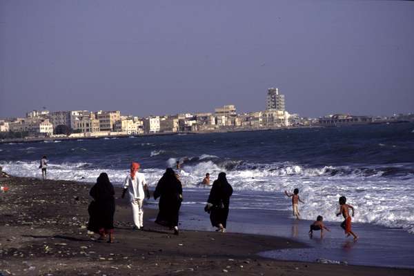 photo of South Yemen, Gulf of Aden, Yemeni man with 3 covered women on the beach of Al Mukalla