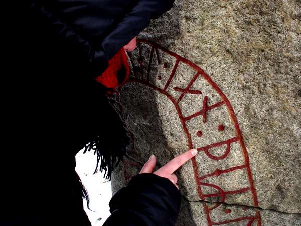 photo of Sweden, Lund, touching the red lettres of a rune stone written in the old alphabet which the Vikings used