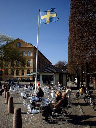 photo of Sweden, Stockholm, a terrace below a Swedish flag close to the Stockholm Stadshuset